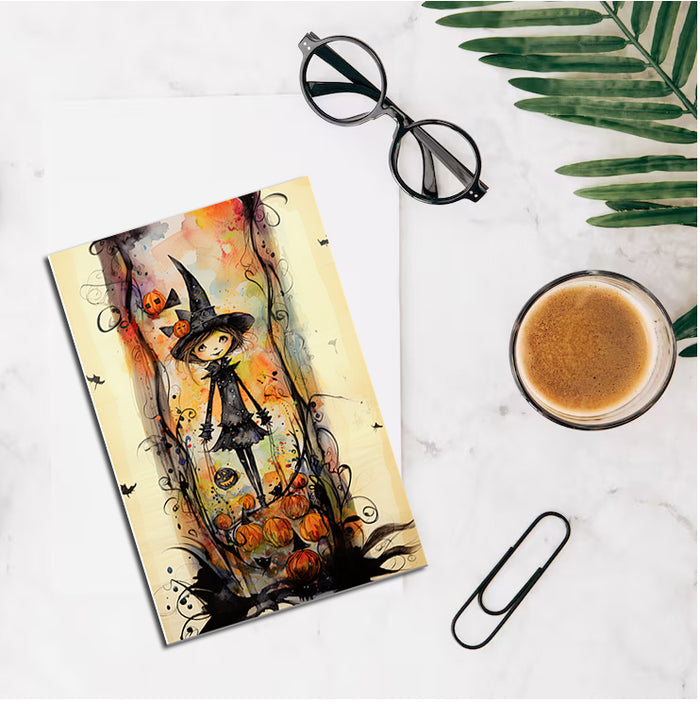 Colorful Halloween-themed notebook with a cup of coffee, glasses, and a paperclip on a marble surface.