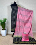 Black Katan silk suit set hand block printed with yellow and white geometric starburst motifs, paired with a contrast pink dupatta printed in floral clusters with banded edges.