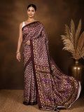 Dark brown and tan abstract geometric printed saree with a mauve accent and narrow brown border, styled with a reference blouse.
