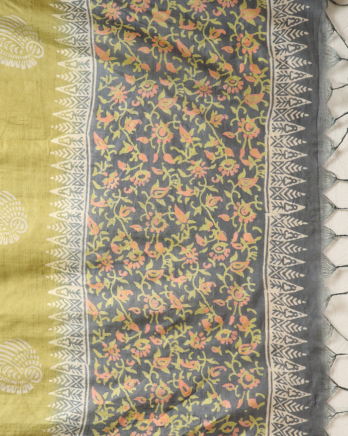 Charcoal grey and olive green Katan silk unstitched suit set with all-over floral paisley block print in muted earth tones, peach and pale yellow accents and a tasselled dupatta