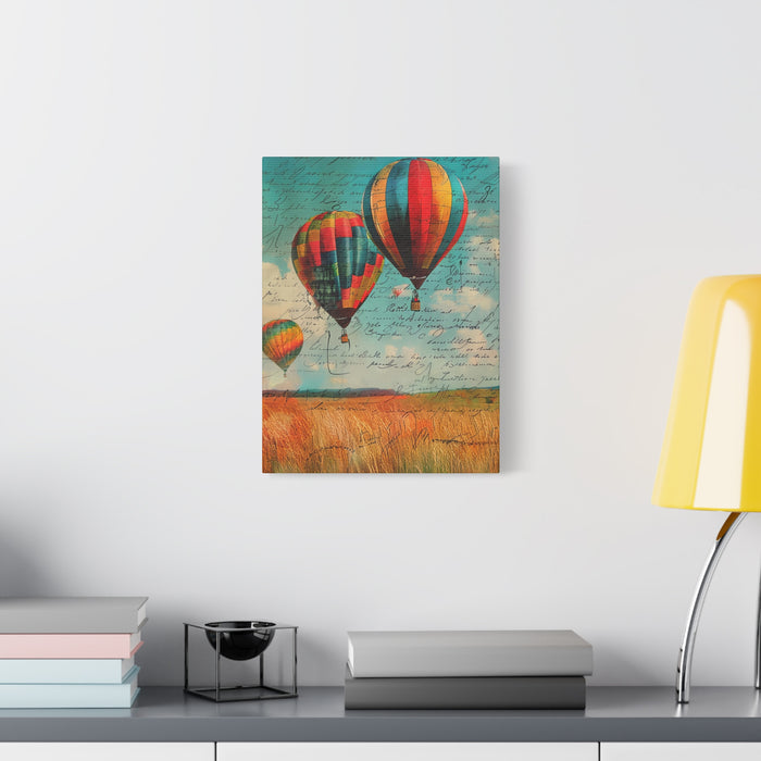 Canvas print of hot air balloons in a field on a wall above a desk with books and a lamp.
