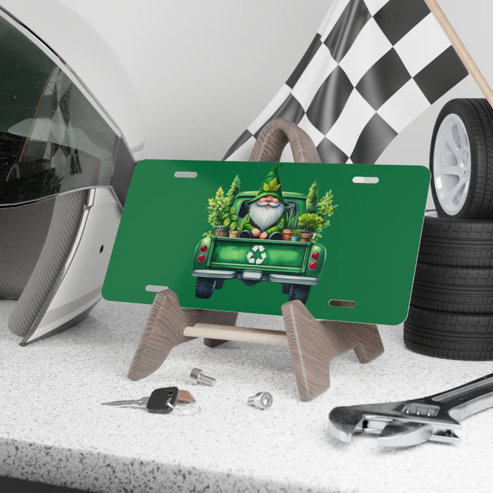 Green license plate with Santa Claus and reindeer design on a stand, surrounded by tools and tires.