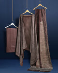 Dark brown Katan silk unstitched suit set with all-over off-white paisley on the top, a plain brown bottom piece and a dupatta with a wide patterned end panel