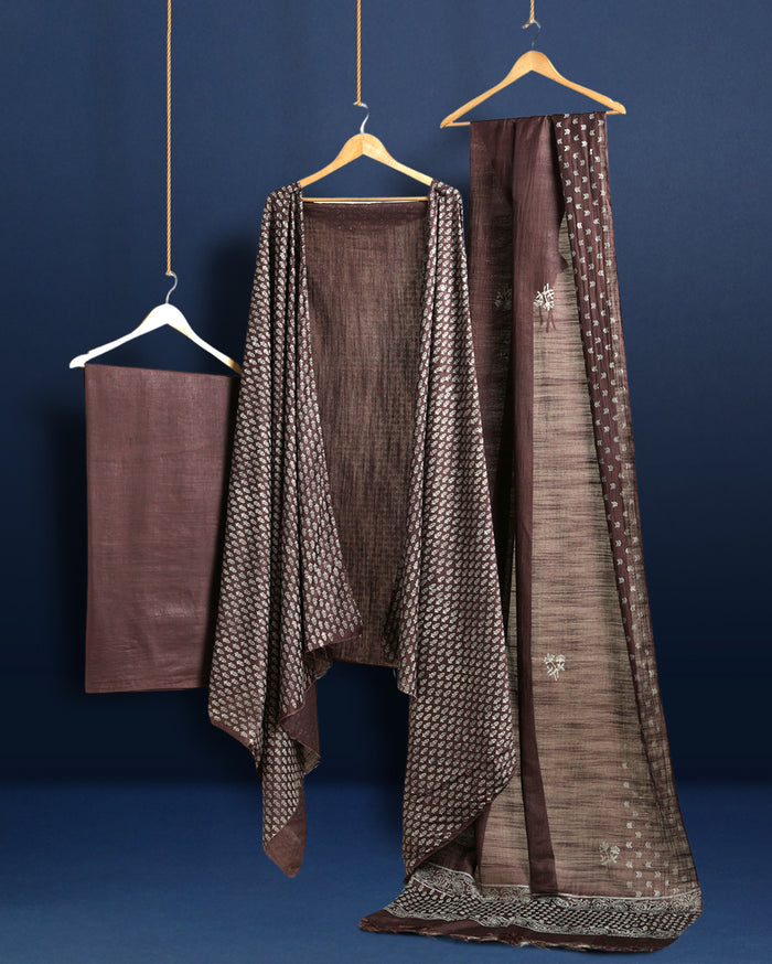 Dark brown Katan silk unstitched suit set with all-over off-white paisley on the top, a plain brown bottom piece and a dupatta with a wide patterned end panel