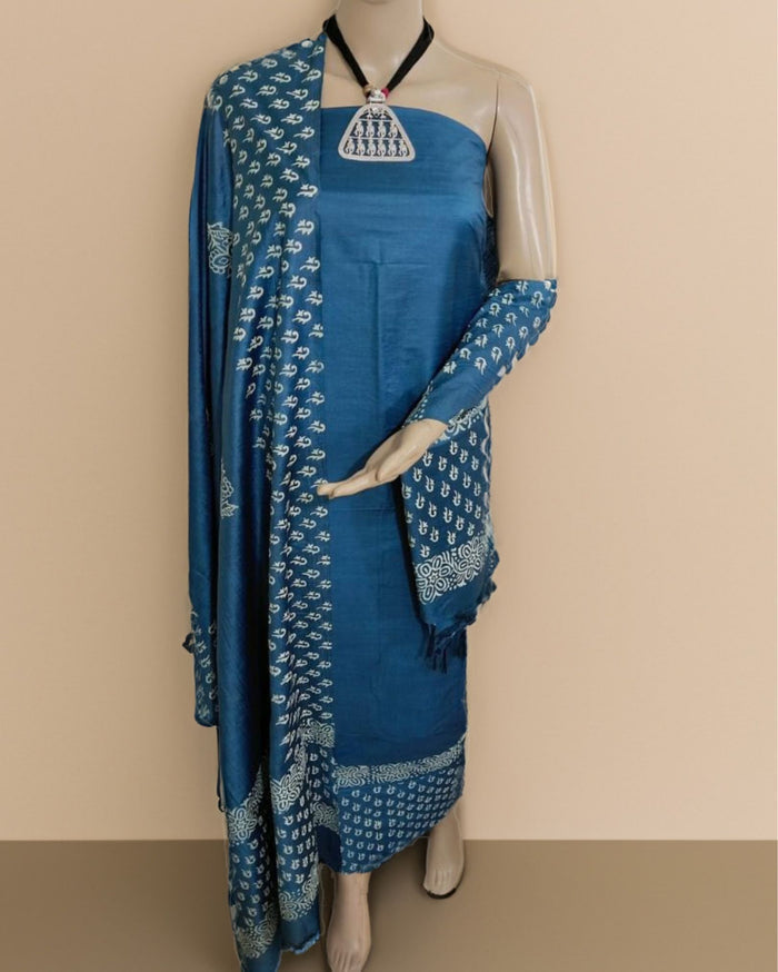 Deep blue katan silk unstitched suit set with small white block-printed florals on the dupatta and sleeve pieces and a near-plain body.