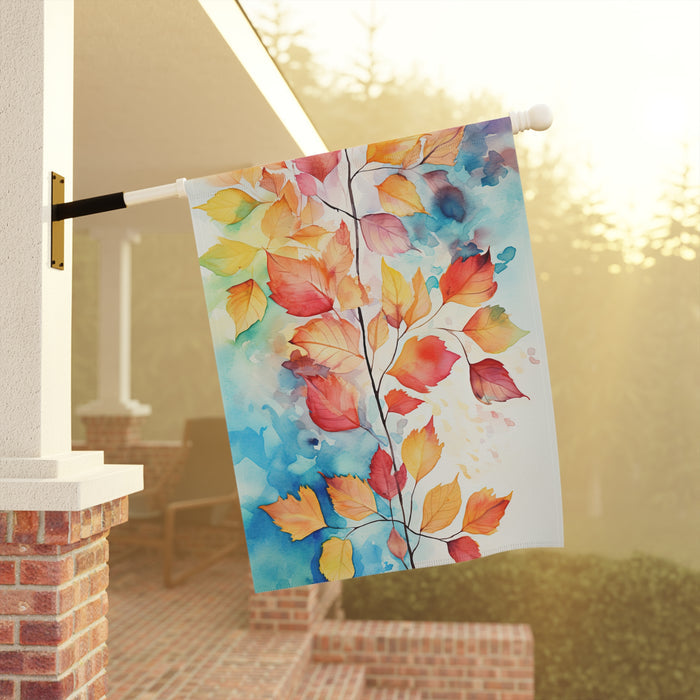 Decorative towel with autumn leaf design hanging on a railing outdoors.