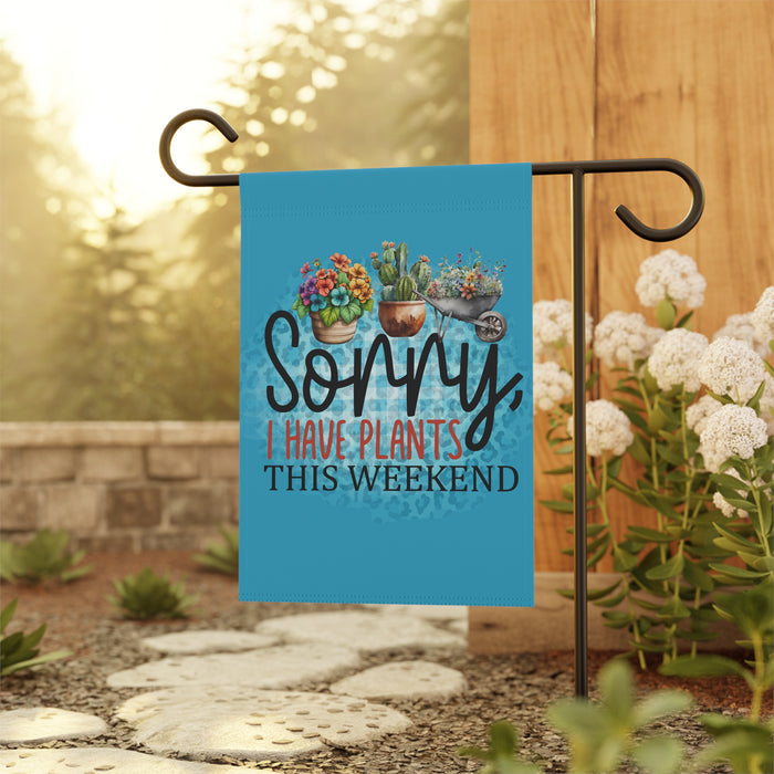 Garden flag with plant-themed text on a stand outdoors