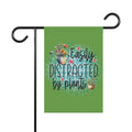 Garden flag with 'Easily Distracted by Plants' text and plant illustrations on a green background.