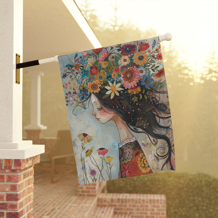 Decorative flag with a colorful design of a woman with flowers in her hair, hanging on a pole.