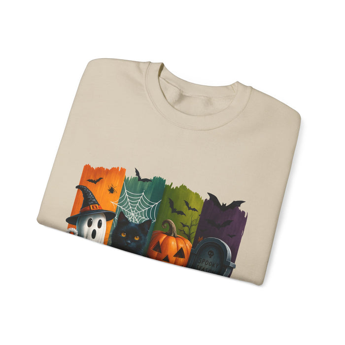 Folded beige sweatshirt with Halloween-themed design on a white background