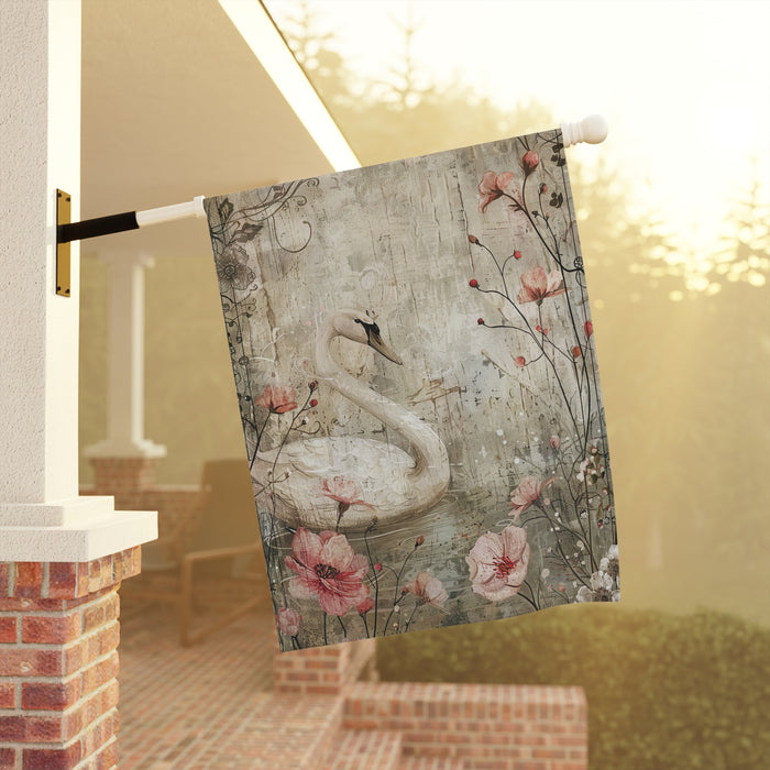 Decorative garden flag with a swan and floral design hanging on a porch.