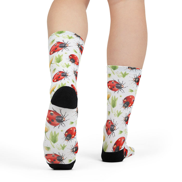 Knee-high socks with ladybug pattern worn by a person on a white background