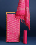 Magenta katan silk unstitched suit set hand block printed with small off-white sprigs, shown with a tasselled dupatta bordered in floral garlands and a plain bottom.