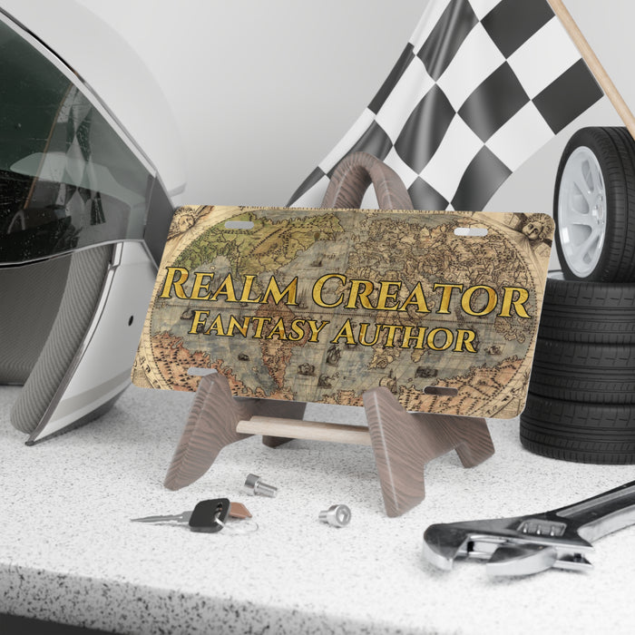 Fantasy-themed license plate with 'Realm Creator Fantasy Author' text, helmet, checkered flag, and tools on a gray surface.