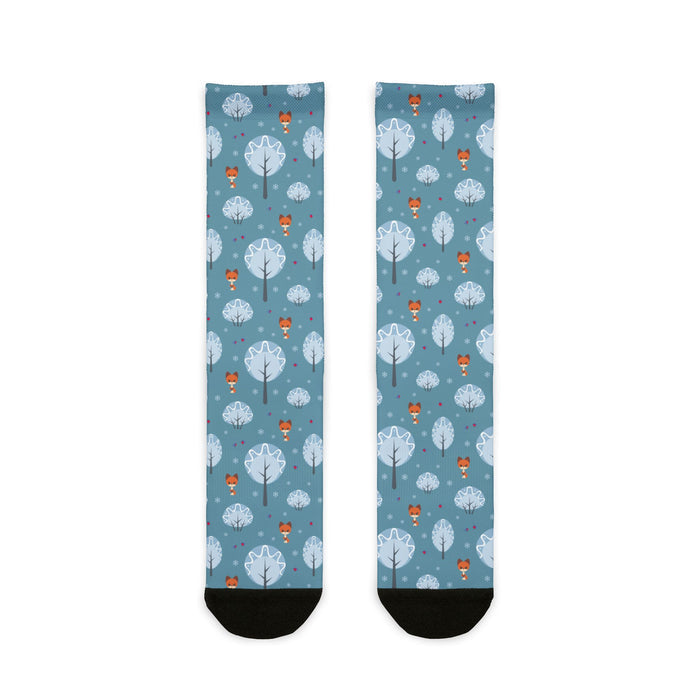 Two socks with a pattern of trees and hot air balloons on a blue background.