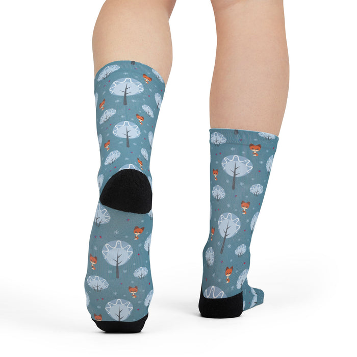 Blue socks with forest pattern worn by a person on a white background