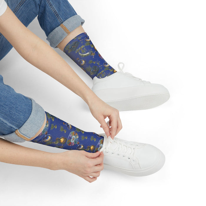 Person wearing blue patterned socks with white sneakers on a white background
