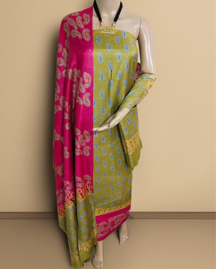 Olive green Katan silk unstitched suit set with a fuchsia pink contrast panel, all-over light blue and beige paisley print, and a paisley border at the hem and along the dupatta edges