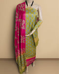 Olive green Katan silk unstitched suit set with a fuchsia pink contrast panel, all-over light blue and beige paisley print, and a paisley border at the hem and along the dupatta edges
