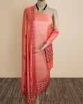 Solid peach katan silk unstitched suit set with a hand block printed dark plum floral panel down one edge of the dupatta and a patterned band at its base.