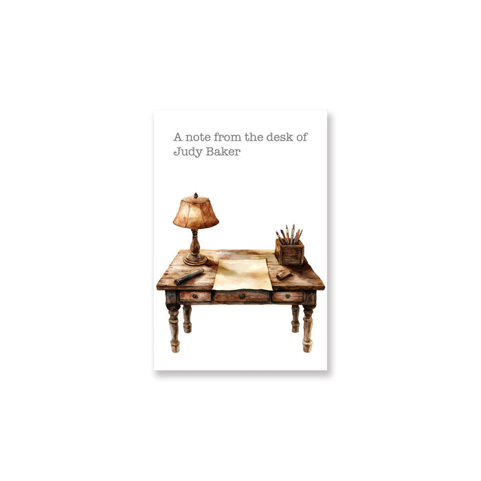 Note card with illustration of a desk, lamp, and stationery on a white background