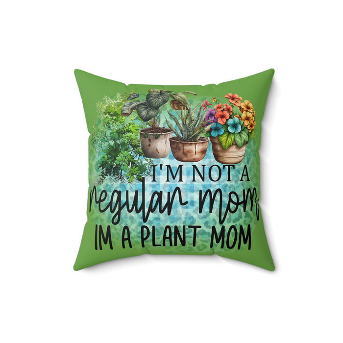 Green pillow with plant-themed design and text 'I'm not a regular mom, I'm a plant mom' on a white background