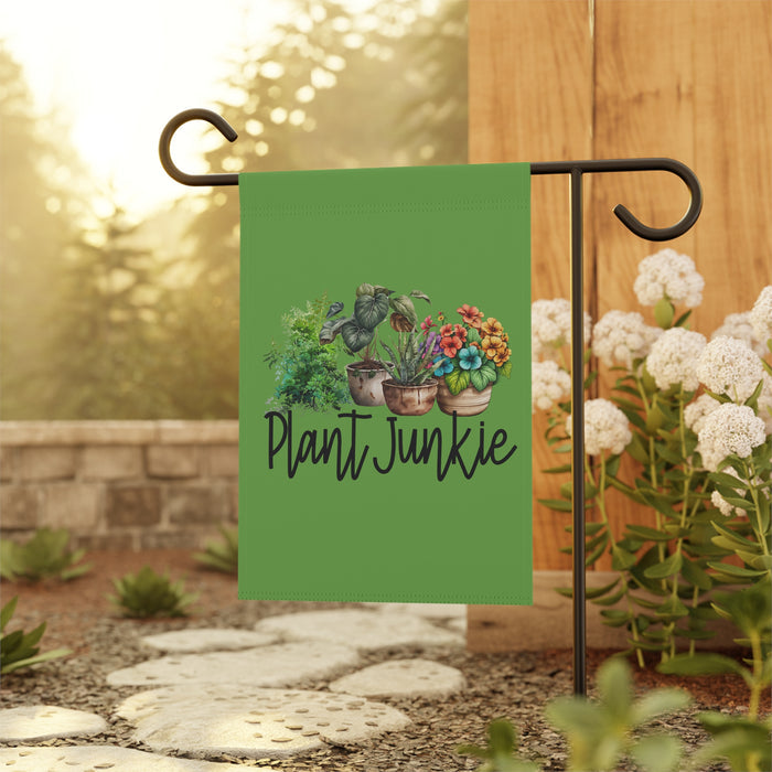 Green garden flag with plant-themed design and 'Plant Junkie' text, displayed outdoors.