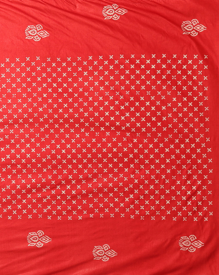 Unstitched red Katan silk suit set block printed with scattered cream and white floral and geometric motifs, a plain unprinted bottom, and a dupatta with a wide floral panel border and a geometric band along the lower edge.