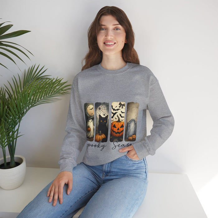 Woman wearing a gray sweatshirt with Halloween-themed design sitting on a white surface.