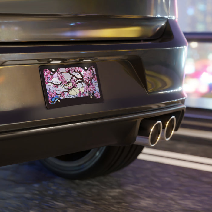 Car rear with decorative license plate featuring cherry blossoms on a blurred street background