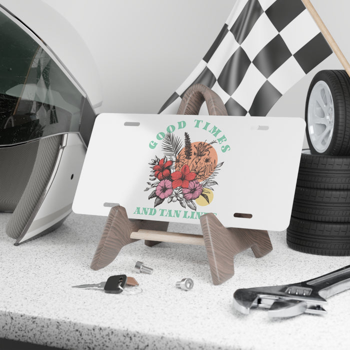 Decorative license plate with floral design and text, placed on a stand with car accessories in the background.
